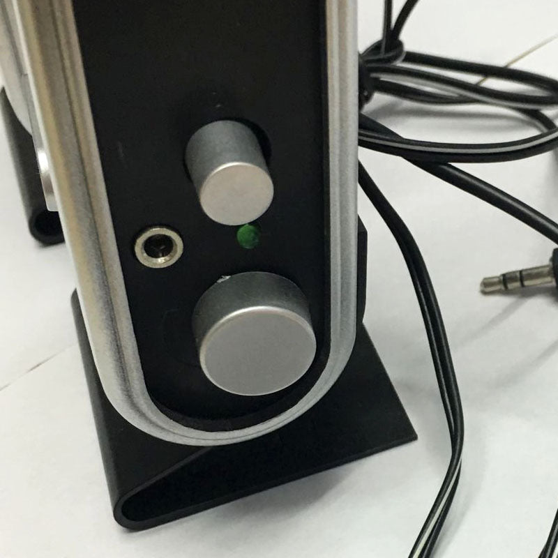 Close-up of a electronic device with knobs and cables on a white surface