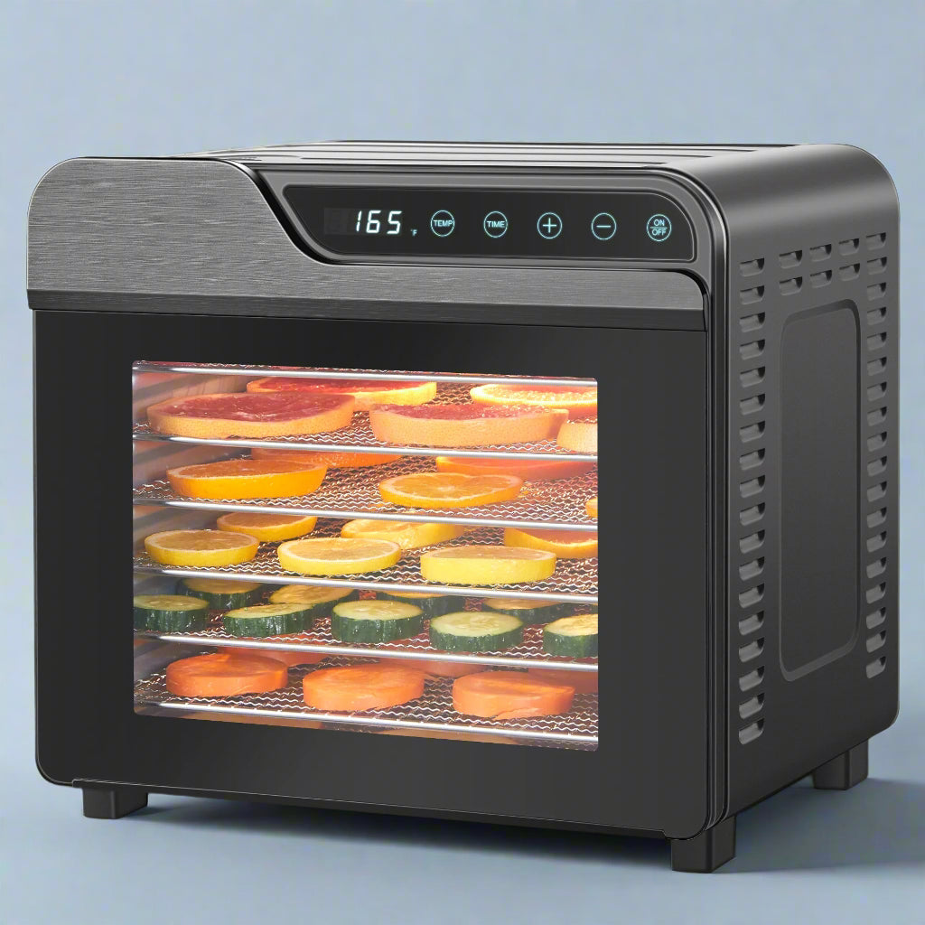 Black food dehydrator with digital display showing temperature, filled with fruits and vegetables on white background
