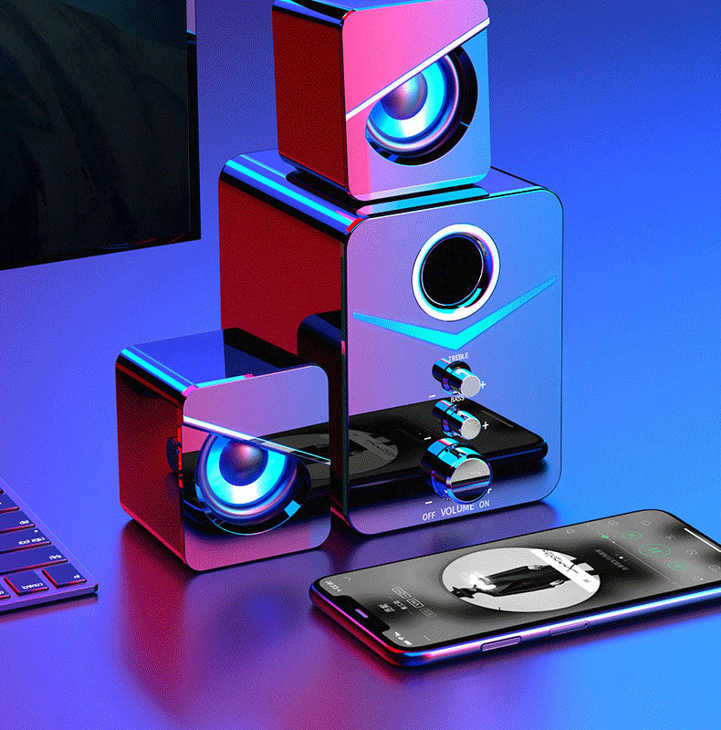 Colorful computer speakers with a smartphone on a reflective surface