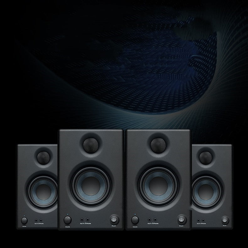 Set of four black studio monitors with a dark background