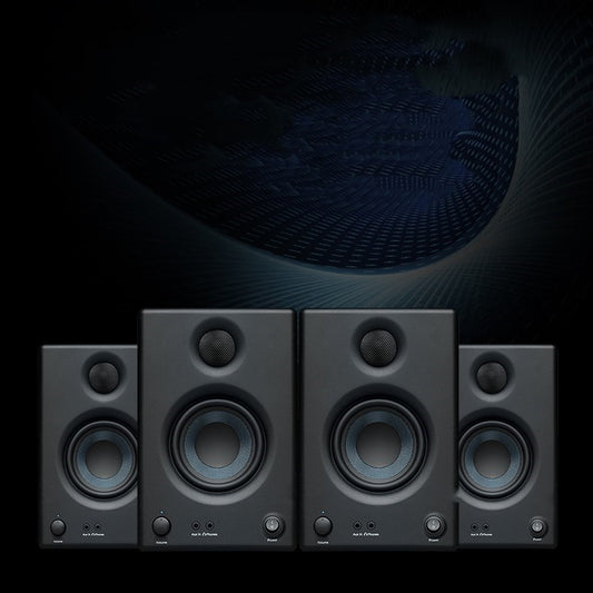 Set of four black studio monitors with a dark background