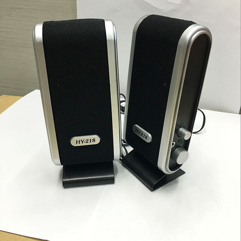 Pair of black and silver speakers with 'HY-218' branding on a white surface.