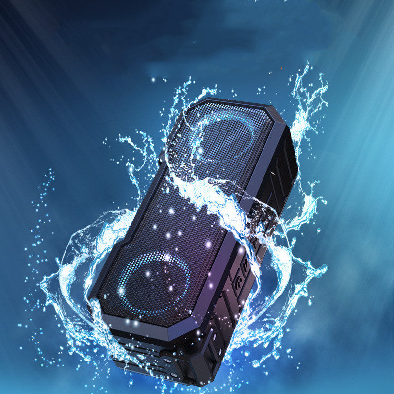 Black portable speaker with water splashes on a blue background