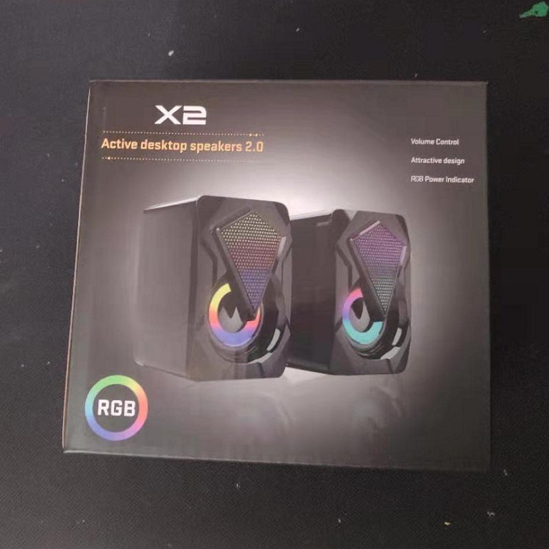 Box of X2 RGB active desktop speakers on a dark background