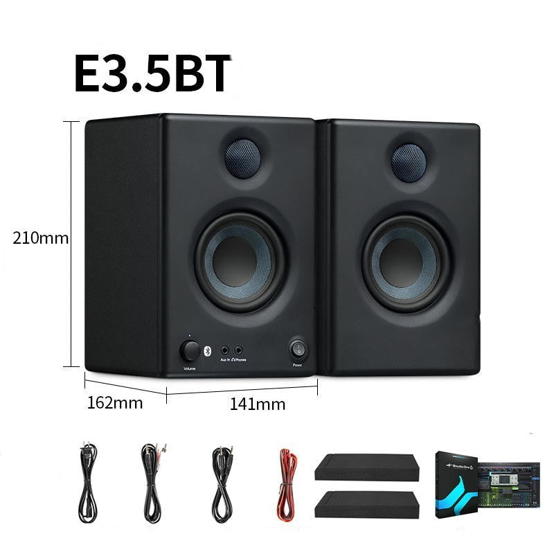 Pair of black studio monitors with Bluetooth and audio cable accessories on a white background.
