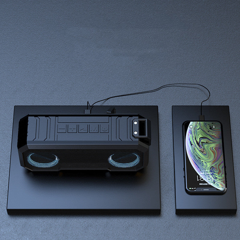 Black gaming console with dual speakers and a smartphone displaying a colorful screen on a dark gray background